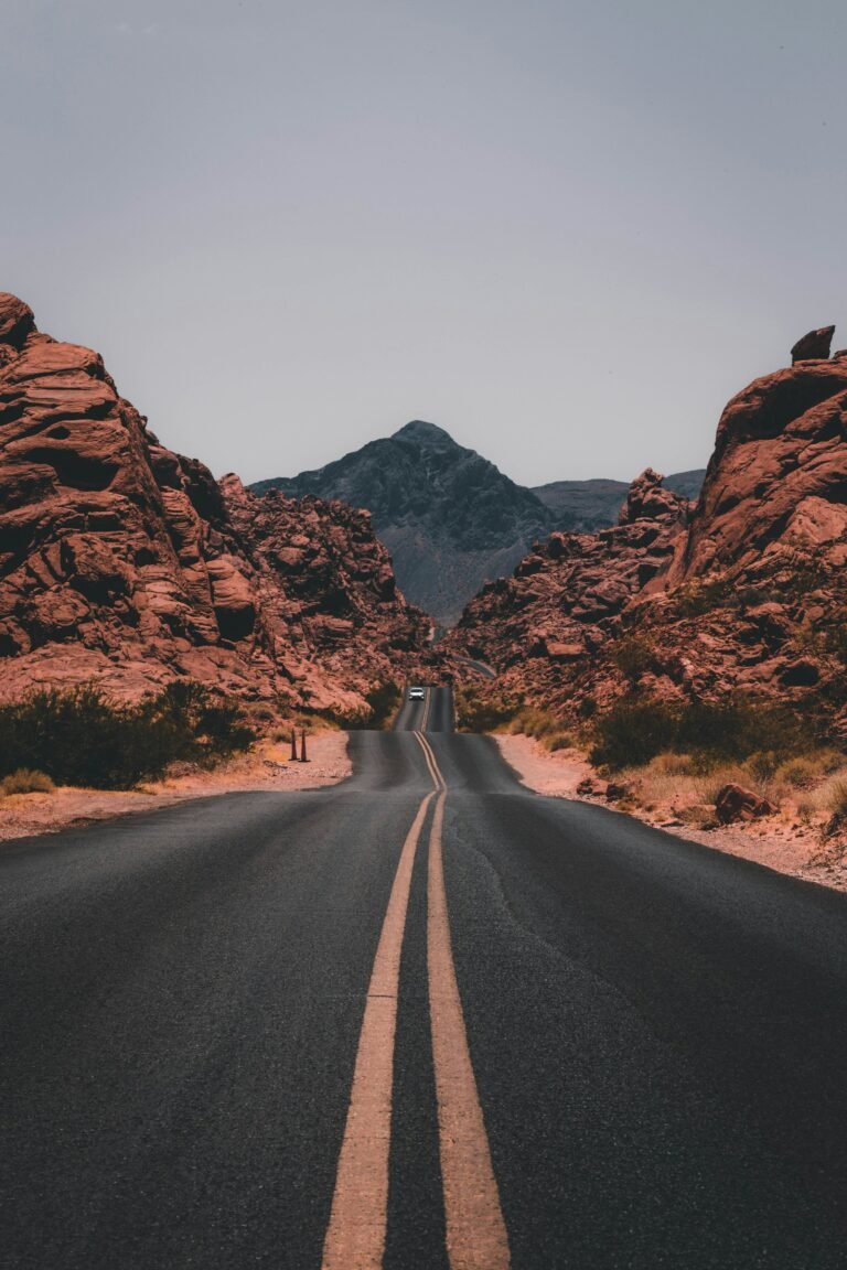 Two-lane road winding through a red-rock desert landscape