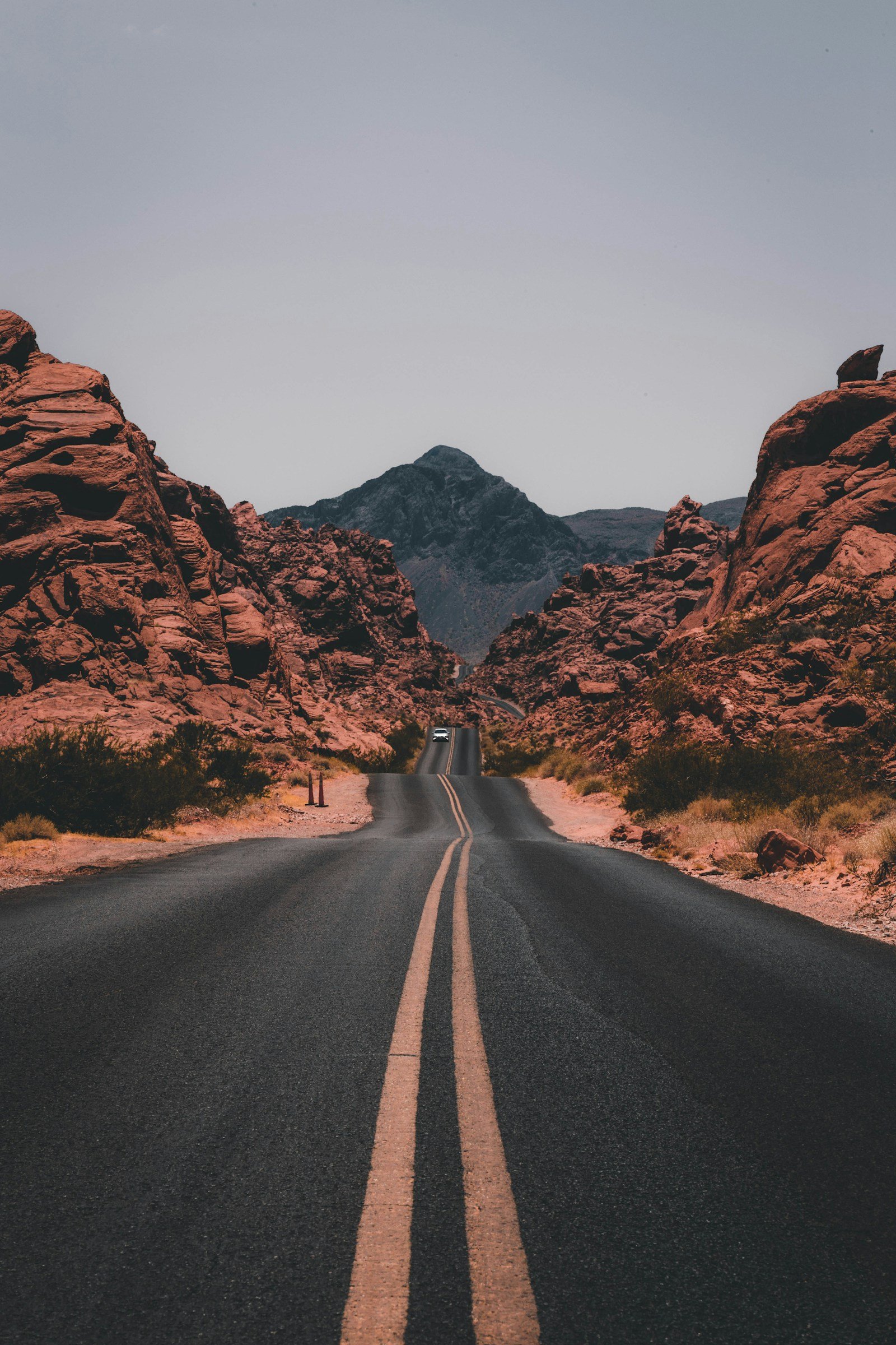 Two-lane road winding through a red-rock desert landscape