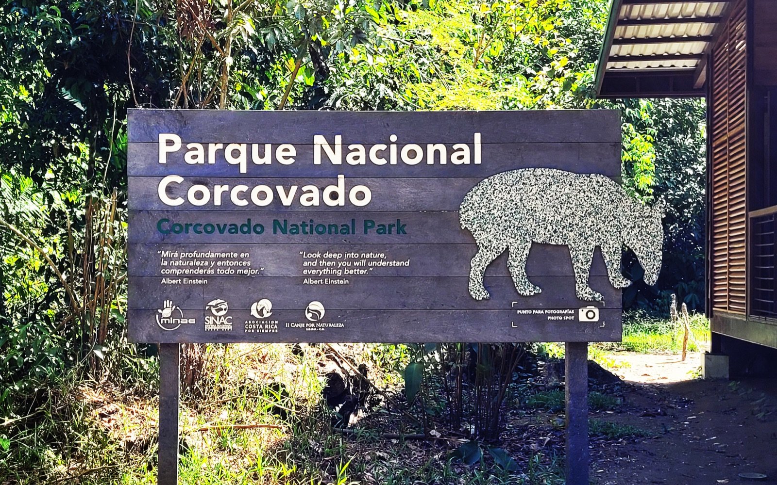 Corcovado National Park entrance sign surrounded by tropical vegetation in Costa Rica