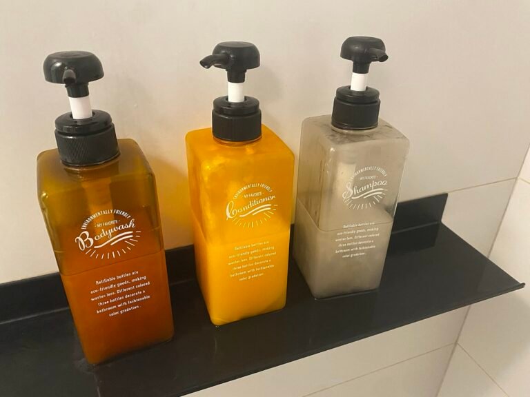 Refillable pump bottles for shampoo, conditioner, and body wash in a hotel bathroom