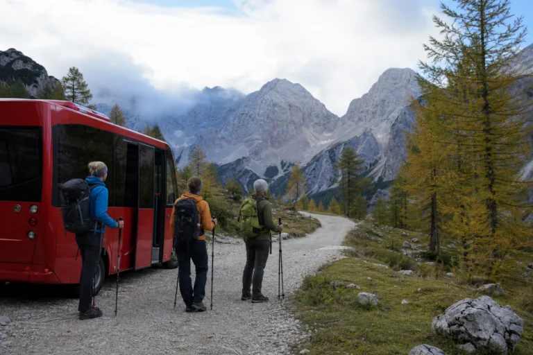 Day hikers stepping from a small red shuttle at a marked alpine trail edge below the Julian Alps